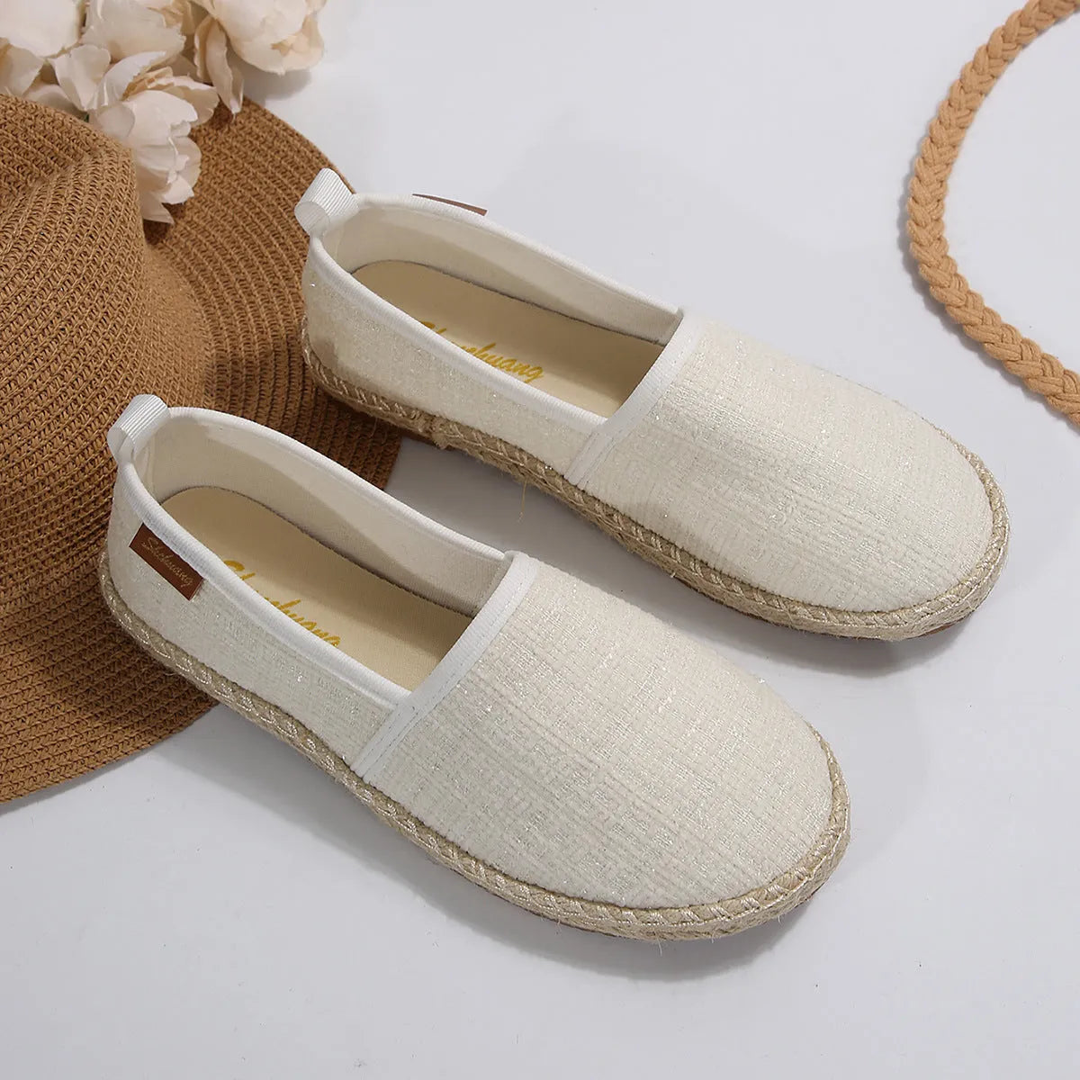 Beige fisherman shoes with canvas upper and rope sole on a flat background
