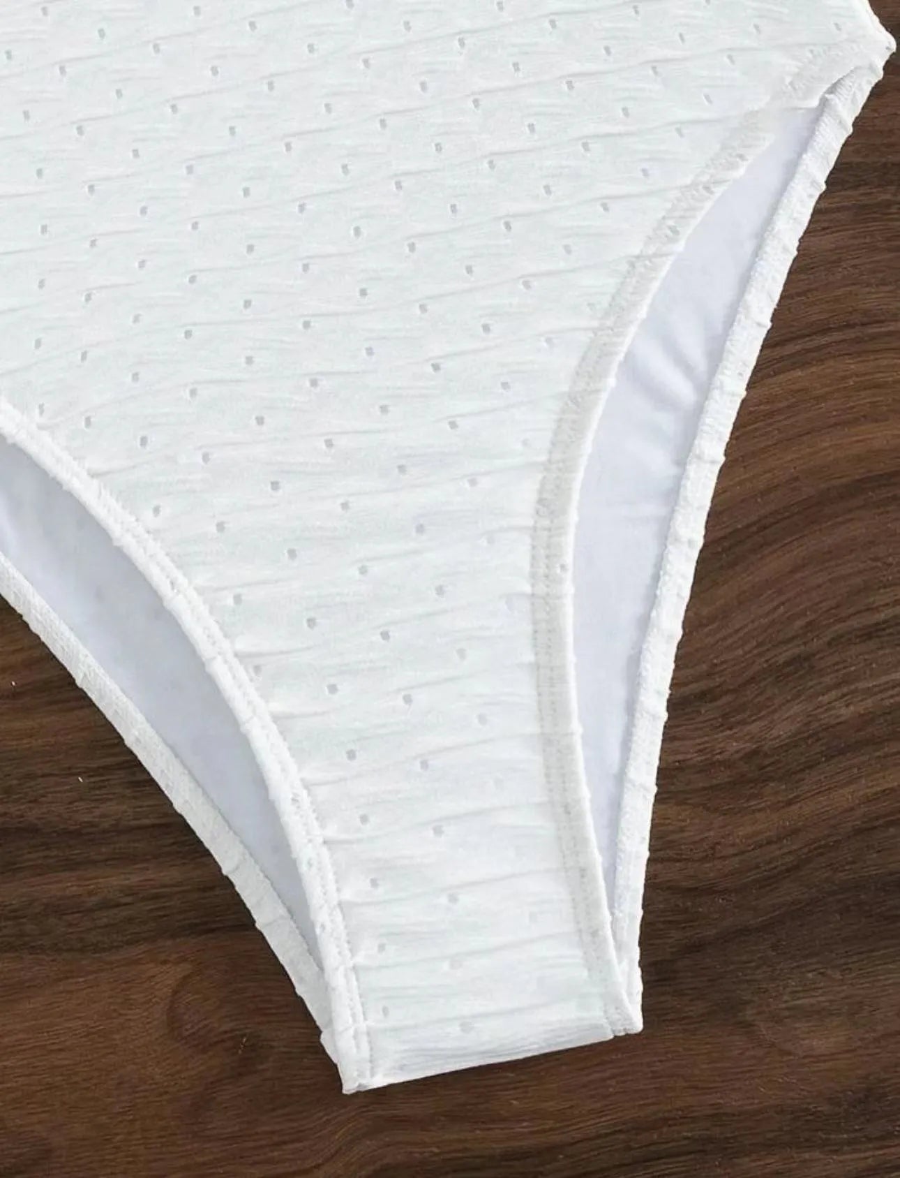 White women's one-piece swimsuit with a sling back design on a mannequin.