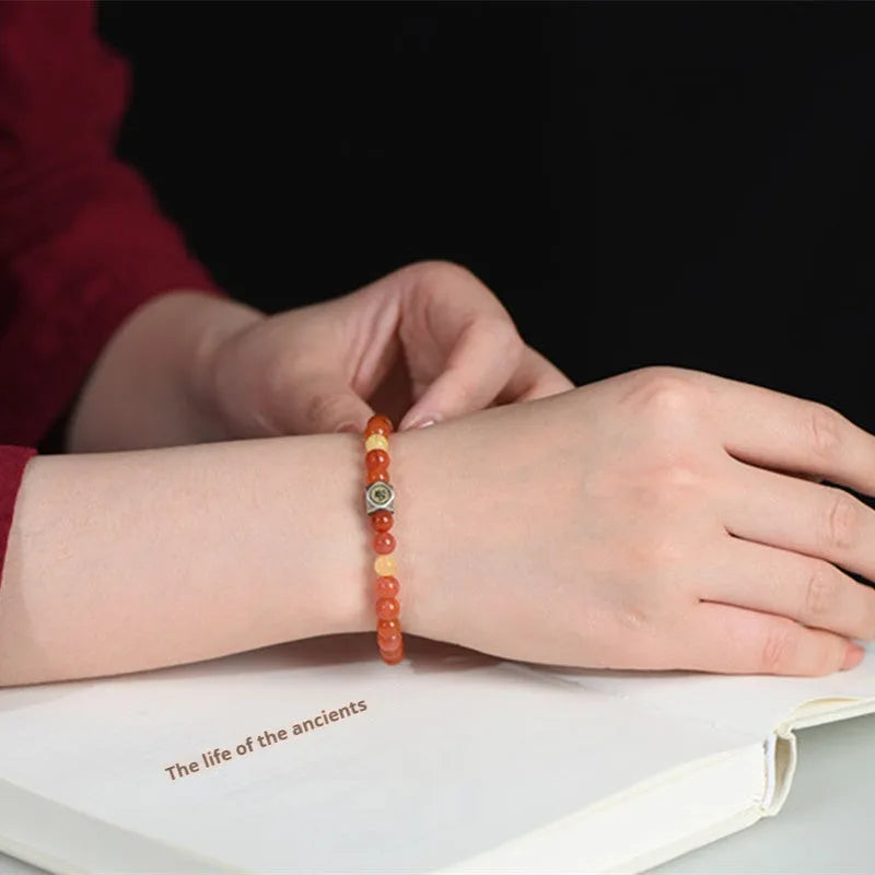 Natural Nanhong agate zodiac bracelet with a beeswax bead shown in 6mm and 8mm size options.