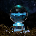 Transparent white crystal ball ornament with inner carving on wooden table with night lamp