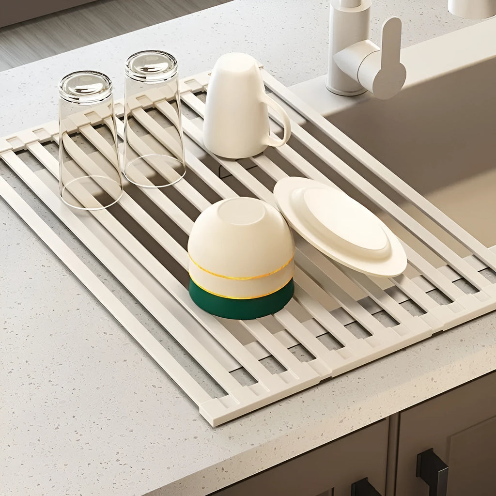 Foldable milky white stainless steel kitchen draining rack shown next to a sink.