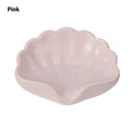 White or pink plastic shell-shaped soap dish for bathroom countertop or shower storage.
