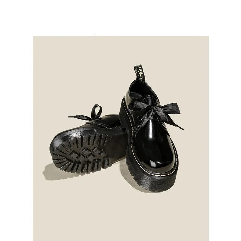 Women's black thick soled leather shoes with cross straps and lace-up closure