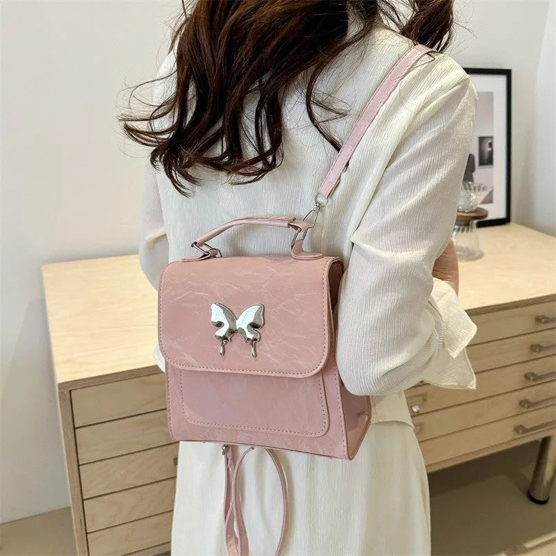Women's preppy style hand-carry backpack in PU leather with bow detailing and mobile phone compartment
