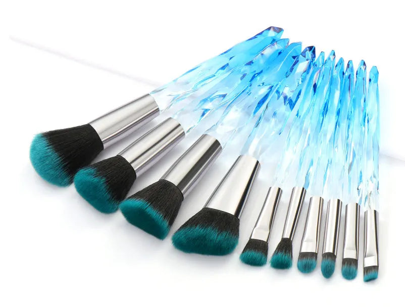 Ten crystal-handle foundation brushes with artificial fibre bristles in black, blue, red, and yellow colours.