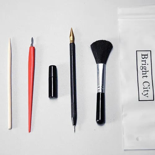 Scraping painting tools set with multiple art tools on white card surface