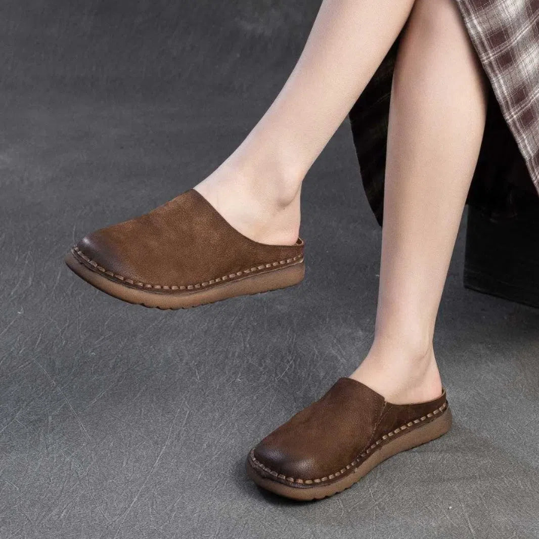 Genuine leather retro wrap-around lazy slippers in brown colour with rubber sole on a neutral background