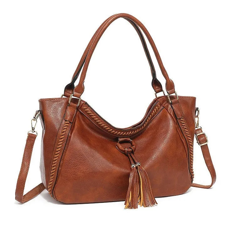 Women's retro PU leather bucket shoulder messenger bag in brown with small bag, placed on a neutral surface showing front view and strap.