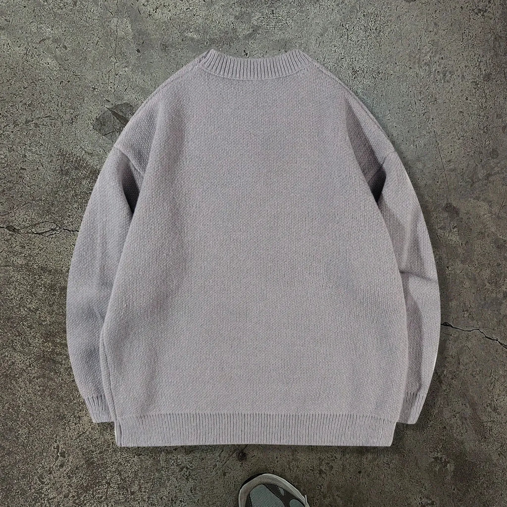 Loose geometric jacquard pullover knitted sweater in gray, front view, showing textured pattern and relaxed fit