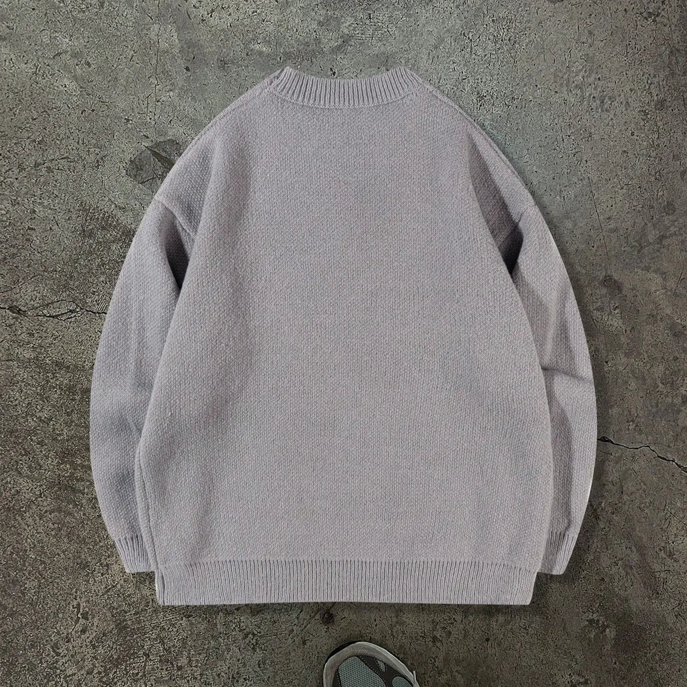 Loose geometric jacquard pullover knitted sweater in gray, front view, showing textured pattern and relaxed fit
