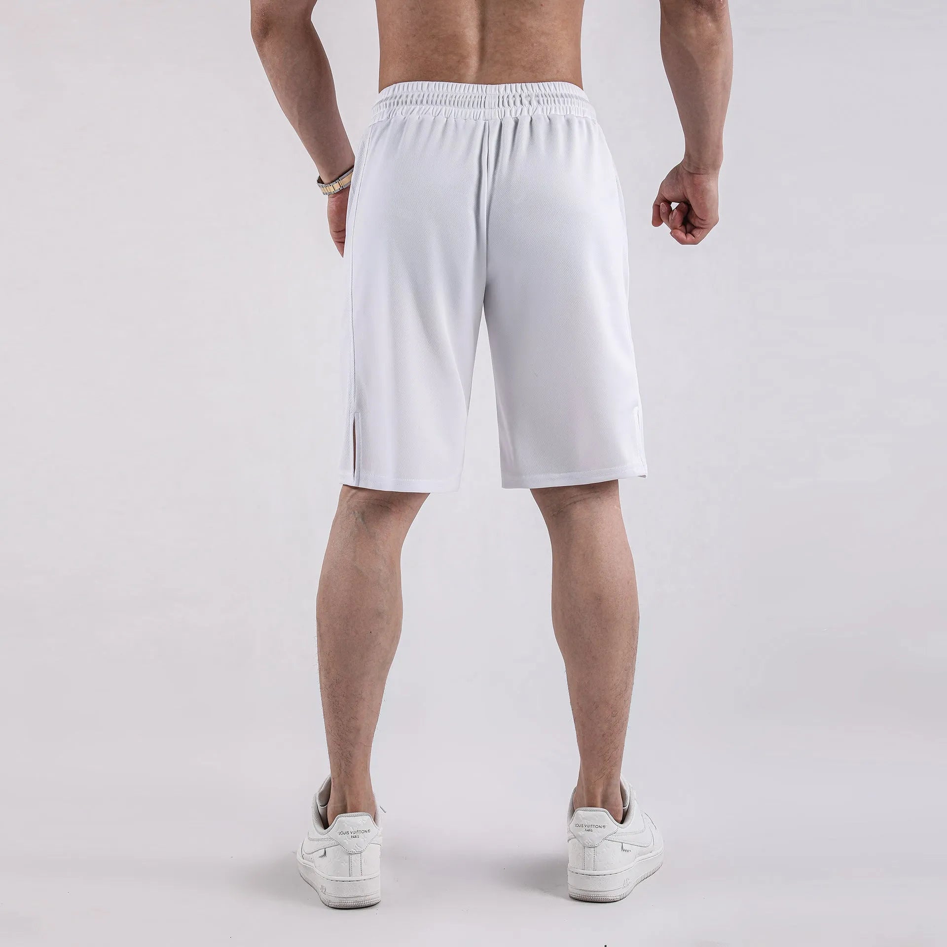 Men's black quick-drying mesh fitness shorts with an elastic waistband, shown in a loose, capri-length style.