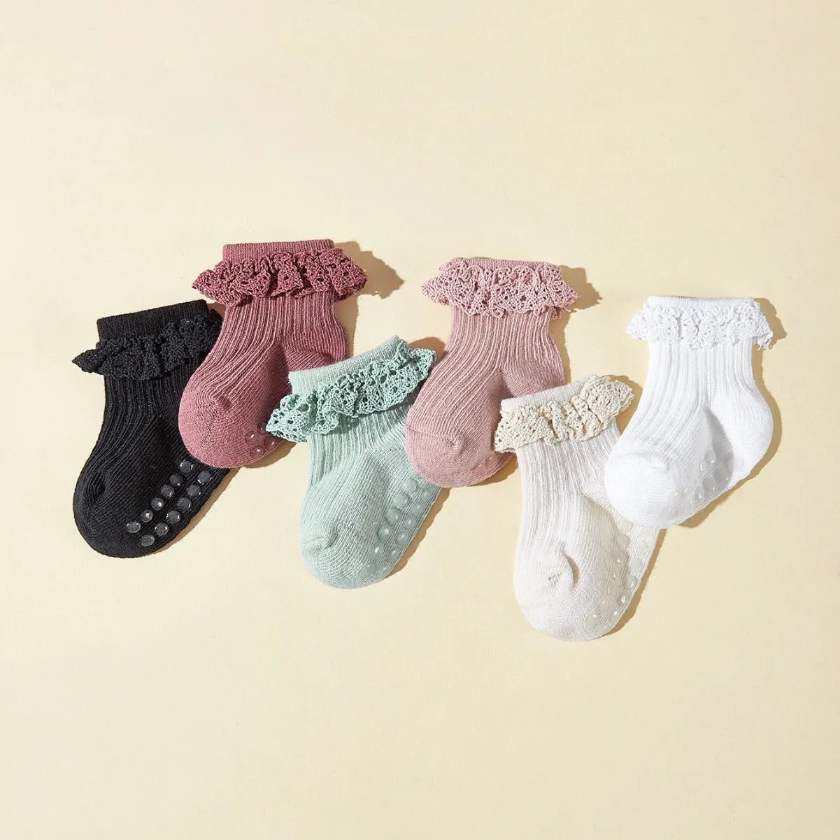 Six pairs of baby girl lace cotton tube socks in mixed colours, short tube length, on white background