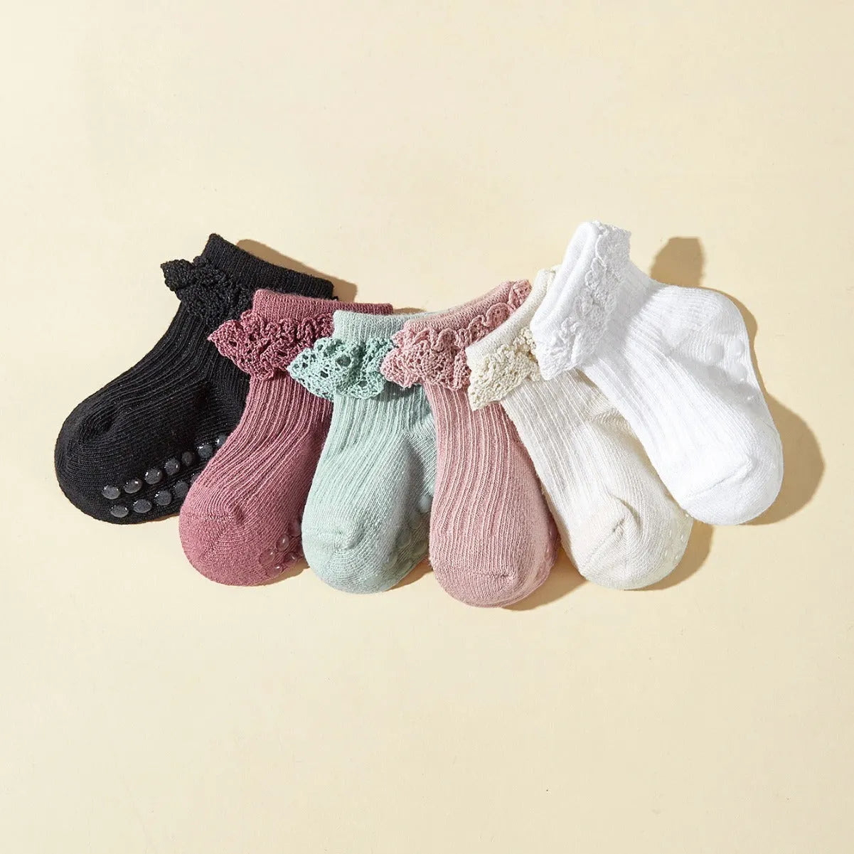 Six pairs of baby girl lace cotton tube socks in mixed colours, short tube length, on white background
