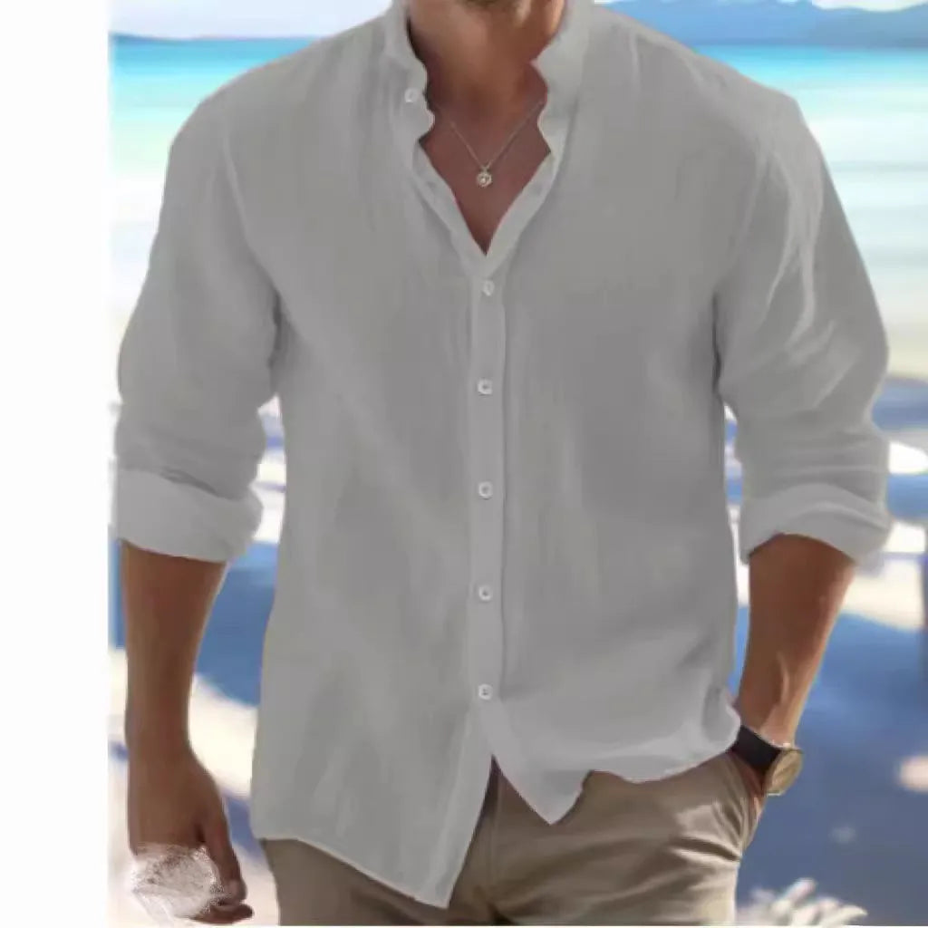 Man wearing a light blue long-staple cotton button-down beach shirt, casual summer style.