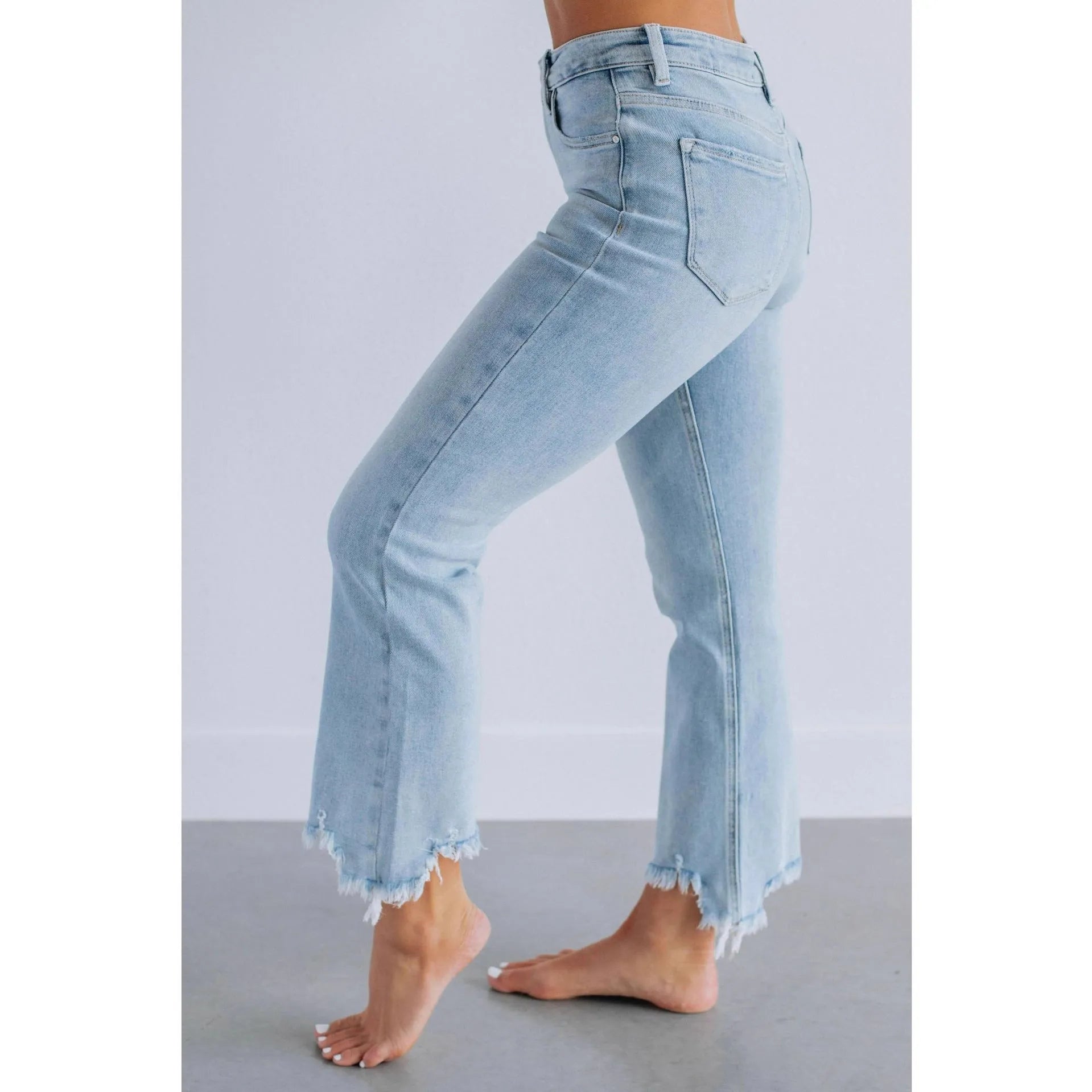 Women's dark blue cotton denim jeans with hand-worn distressing detail on the front.