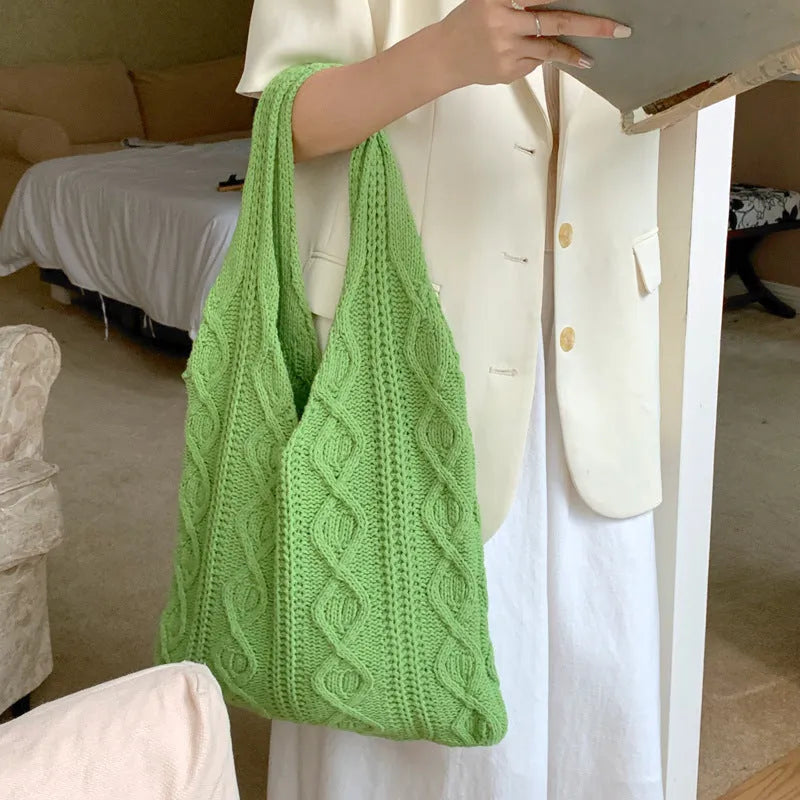 Women's retro-style hollow-knitted wool yarn tote bag in a solid colour, showing double shoulder straps.