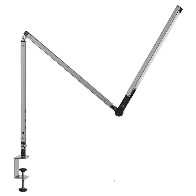 Aluminium clip-on desk lamp with adjustable arm and remote control on a wooden desk.