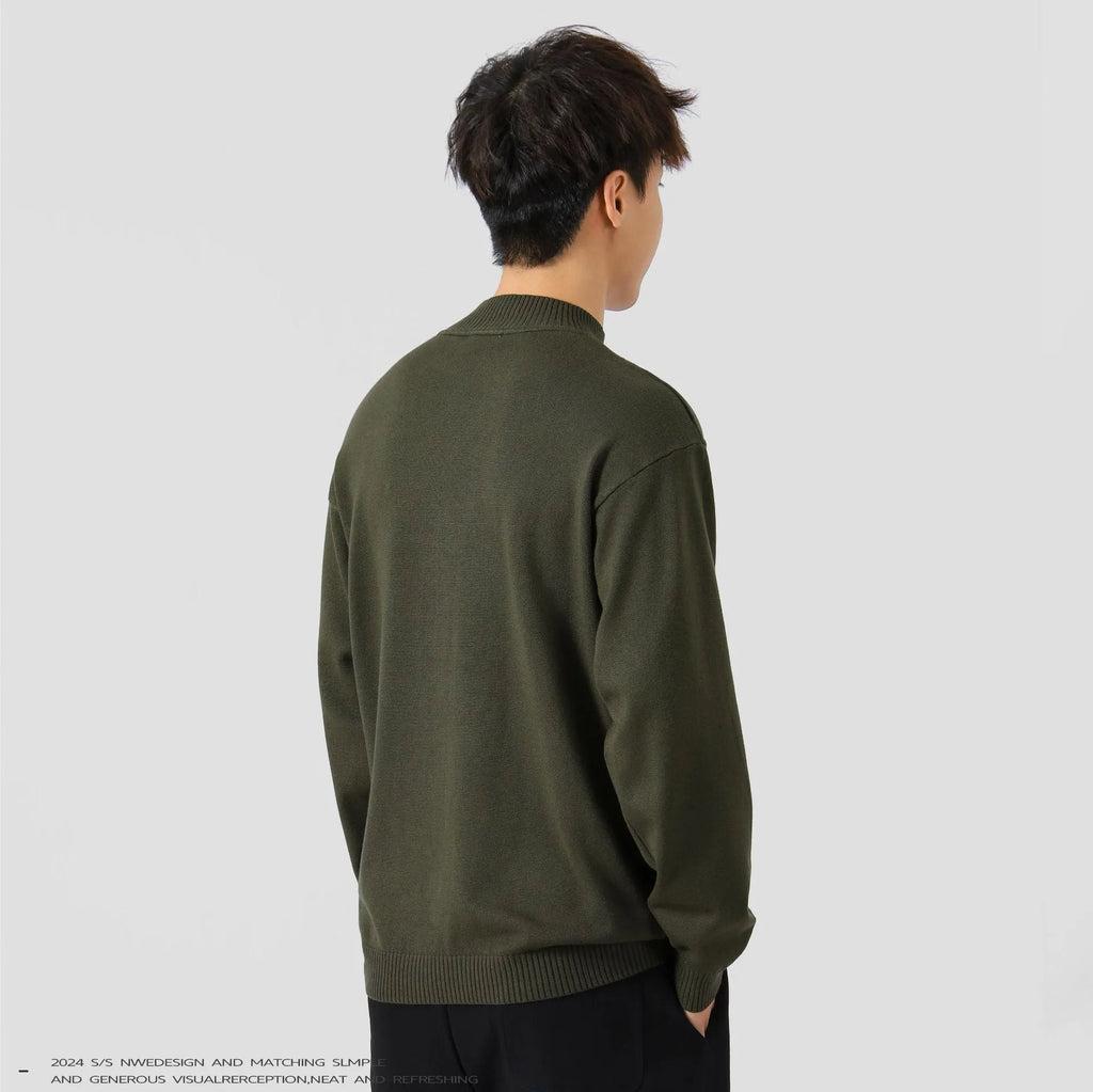 A man wearing a loose-fitting solid colour long sleeve casual pullover sweater.
