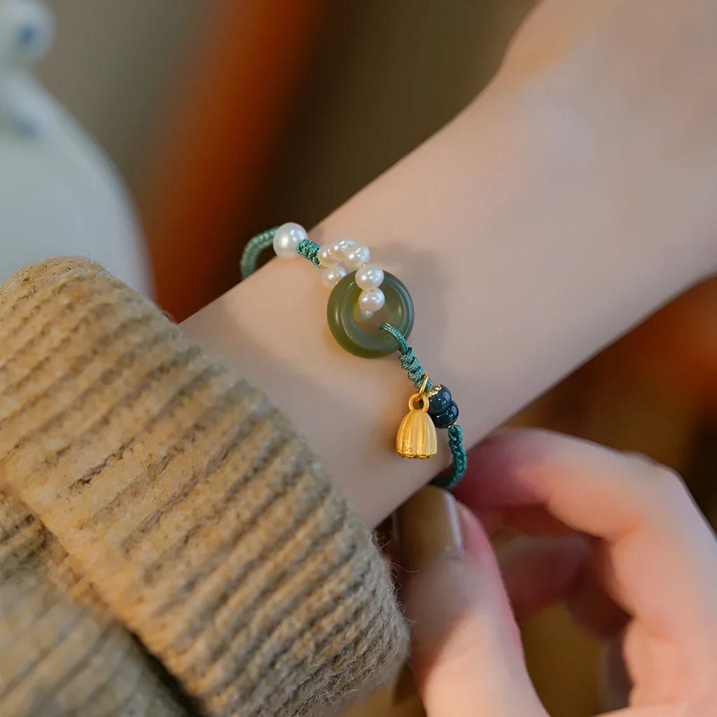 Hand-woven women's watch band with a pearl peace buckle closure on a flexible wire bracelet.