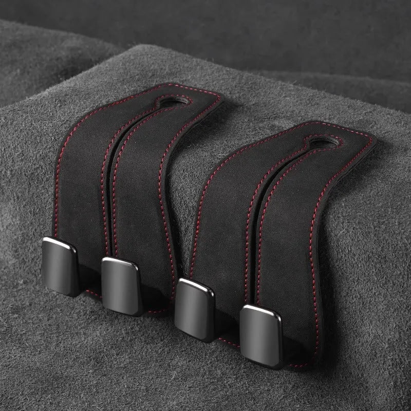 Black suede car seat hook attached to a headrest post, holding a shopping bag.