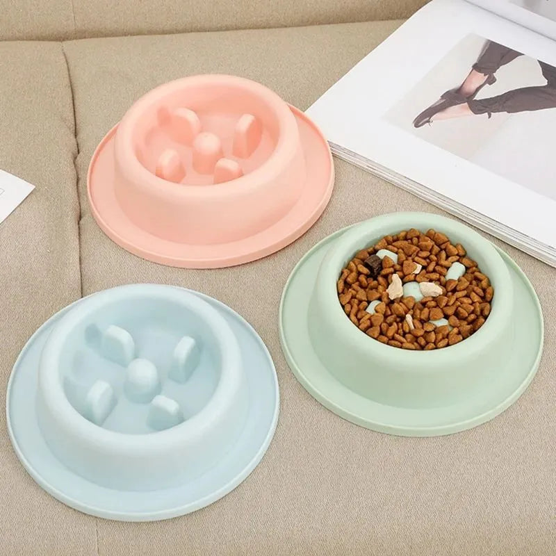 Blue pet slow feeder bowl with maze pattern and non-slip base on a kitchen floor