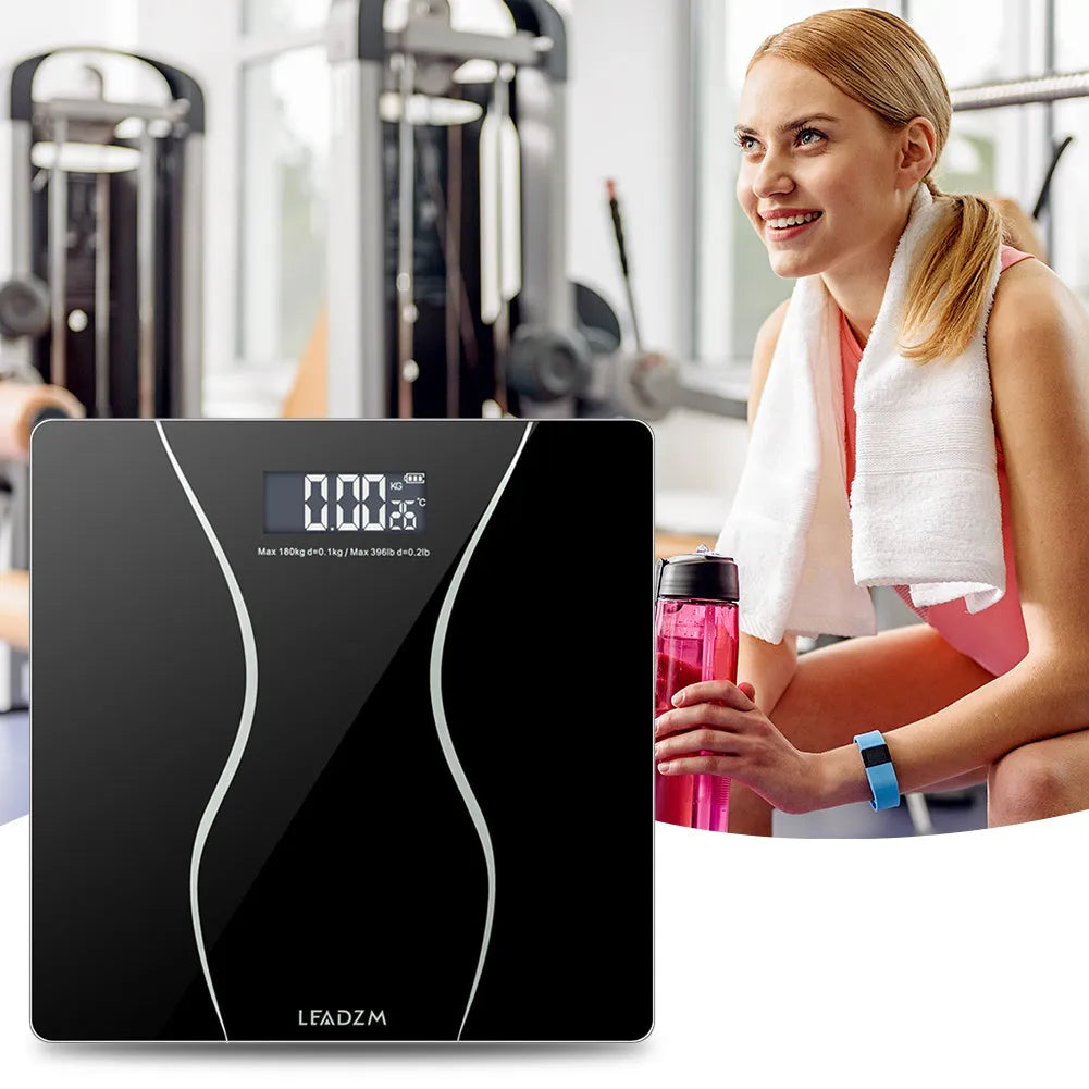 Black electronic bathroom scales with digital display showing weight measurement up to 180kg capacity