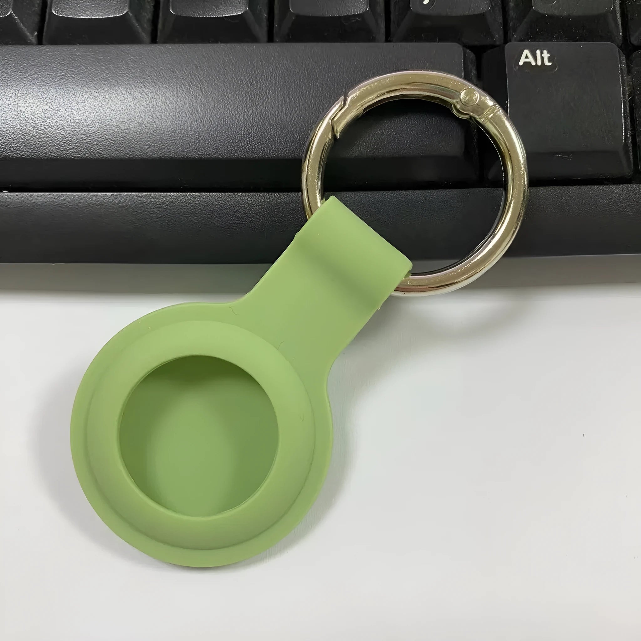 Silicone protective case for Apple AirTag with metal snap button in assorted colours on a keyring.