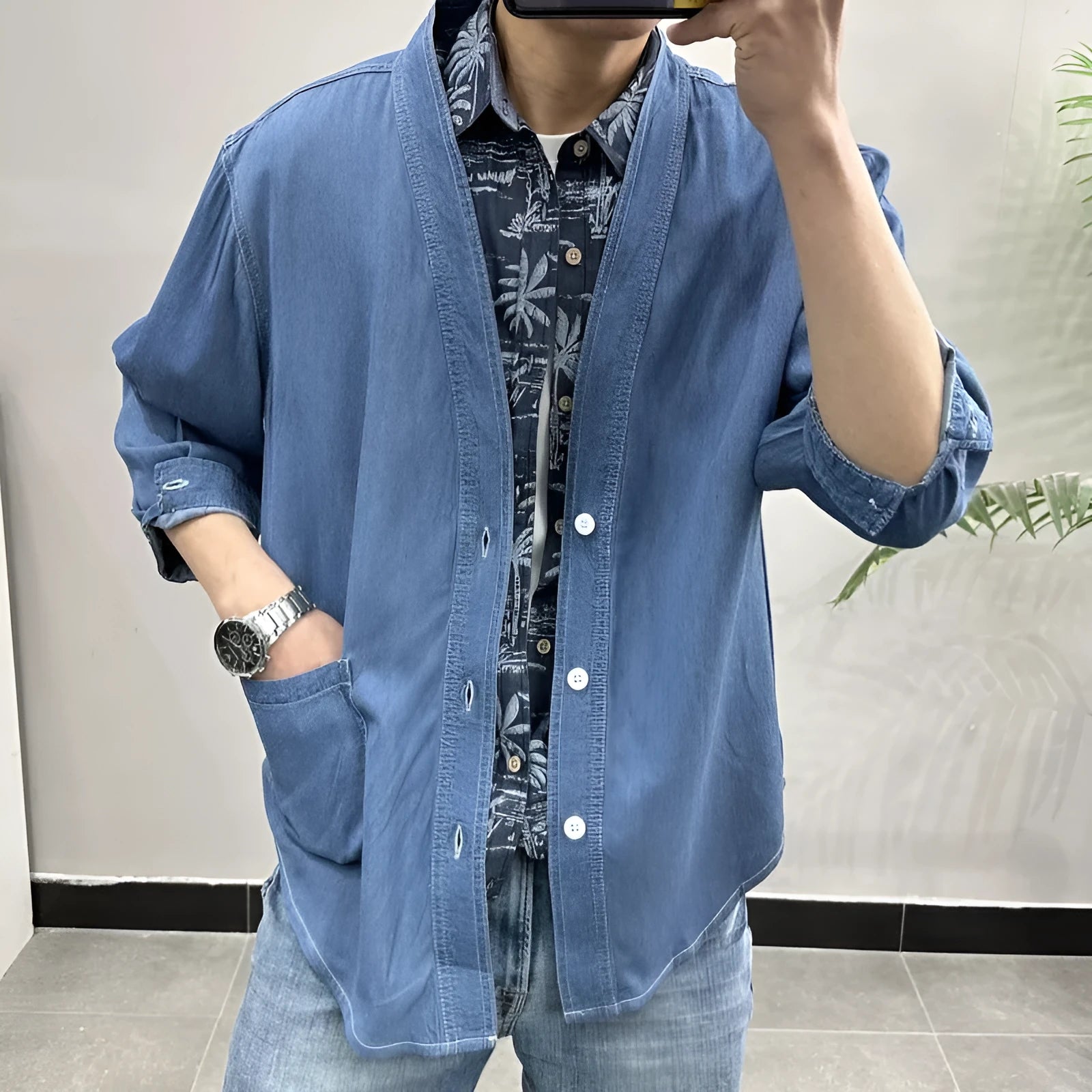 Men's dark blue denim coat with three-quarter sleeves and V-neck collar showing front pocket detail