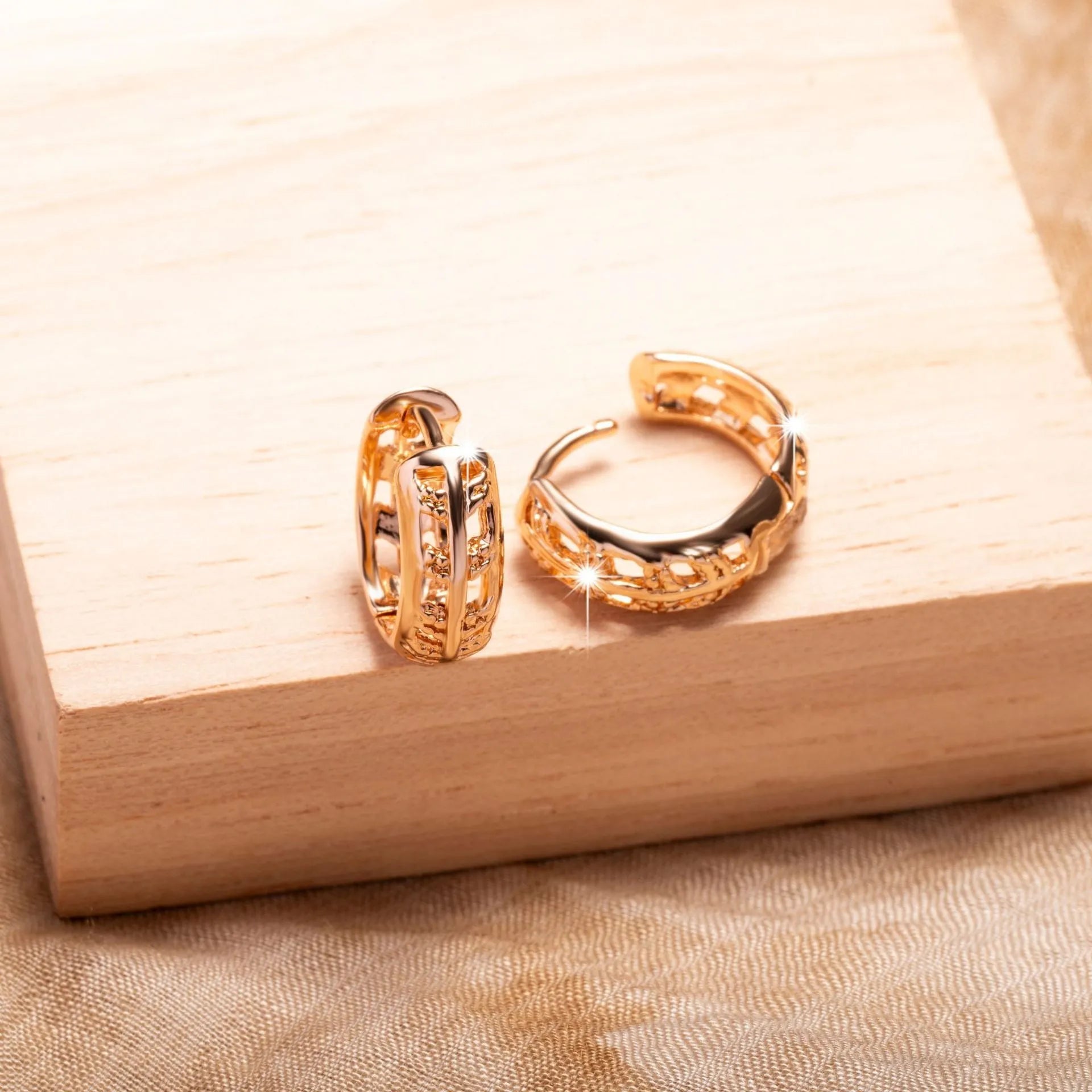 Small copper earrings with a hollow leaf and heart design in a rose gold finish.