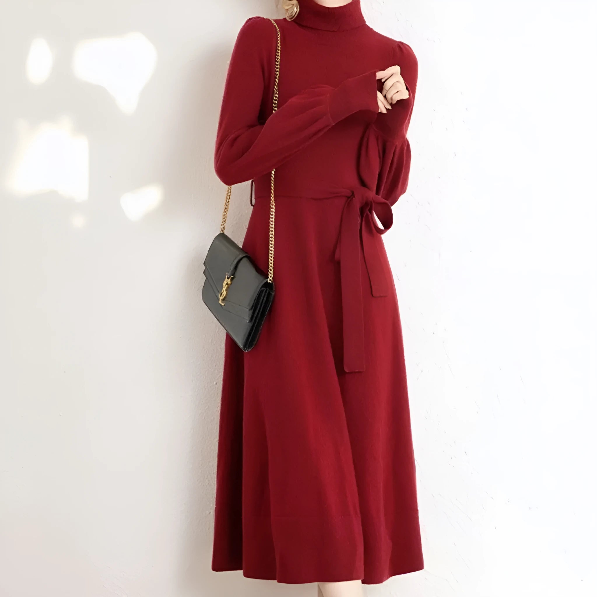 Adult woman wearing a rose red loose-knit turtleneck sweater dress with a flared midi skirt and elastic waist.