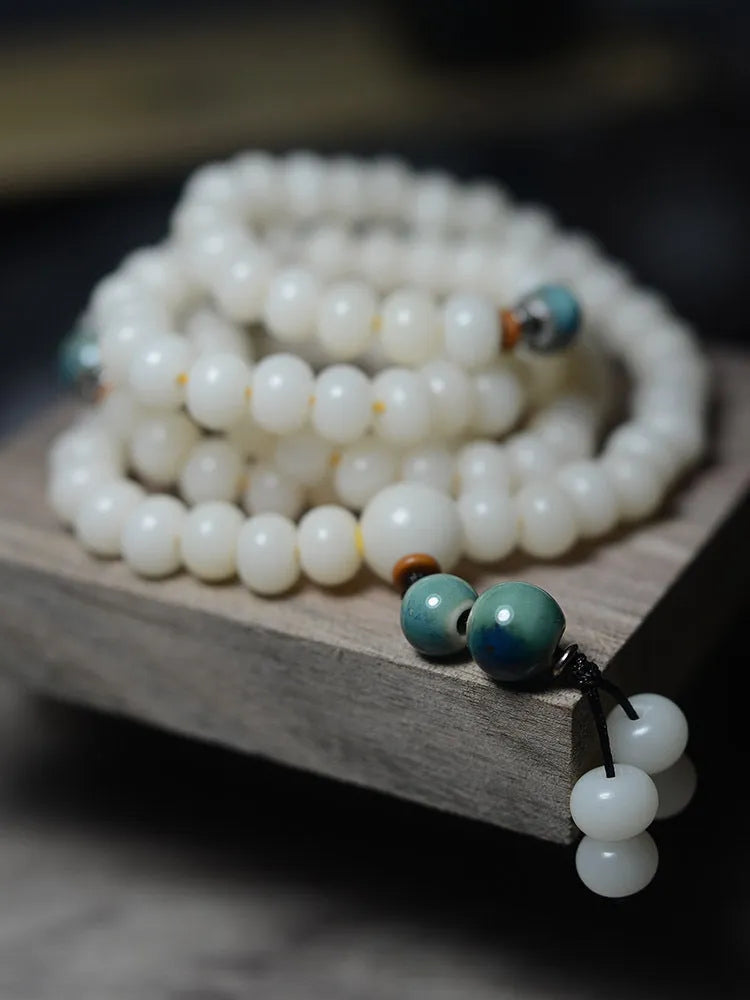 White jade and bodhi seed beaded bracelet with 108 flat round beads in four sizes.
