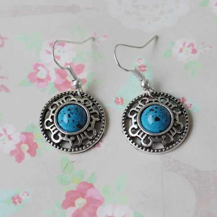 Handmade geometric flower disk earrings made of Tibetan silver and turquoise with ethnic patterns.