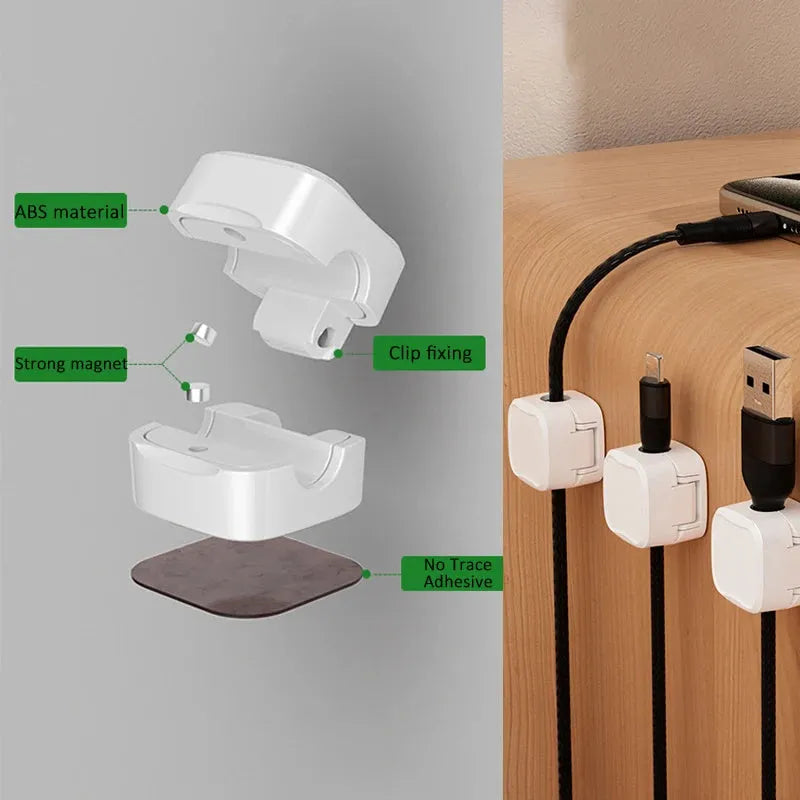White and black magnetic adhesive cable clips holding a USB cable against a wooden desk.