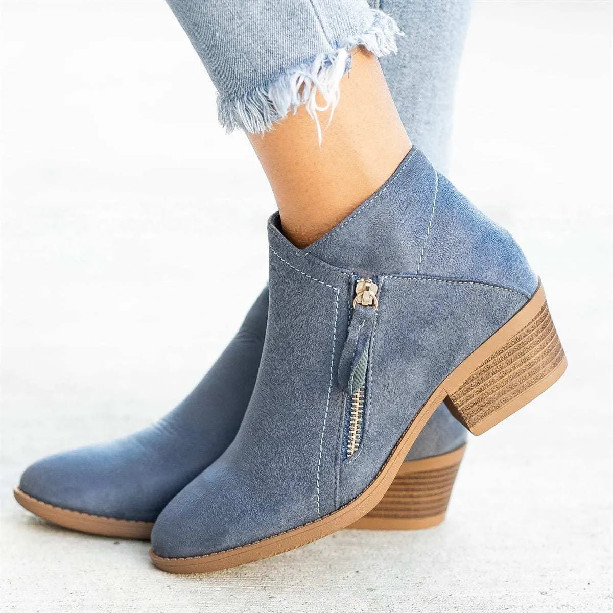 Women's blue suede ankle boots with a chunky heel and a side zip closure on a white background.