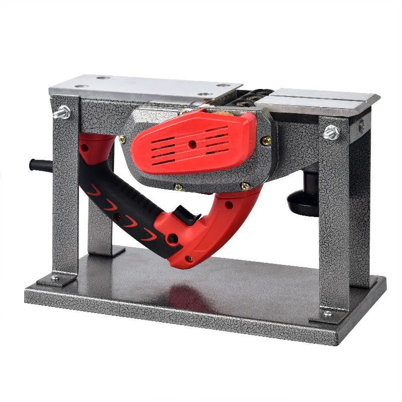 Red desktop electric wood planer with aluminium body on a workbench.