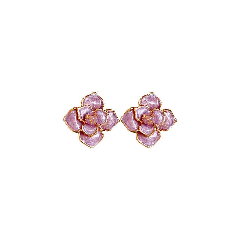 A pair of gold-plated purple floral stud earrings with silver needle details on a white background.