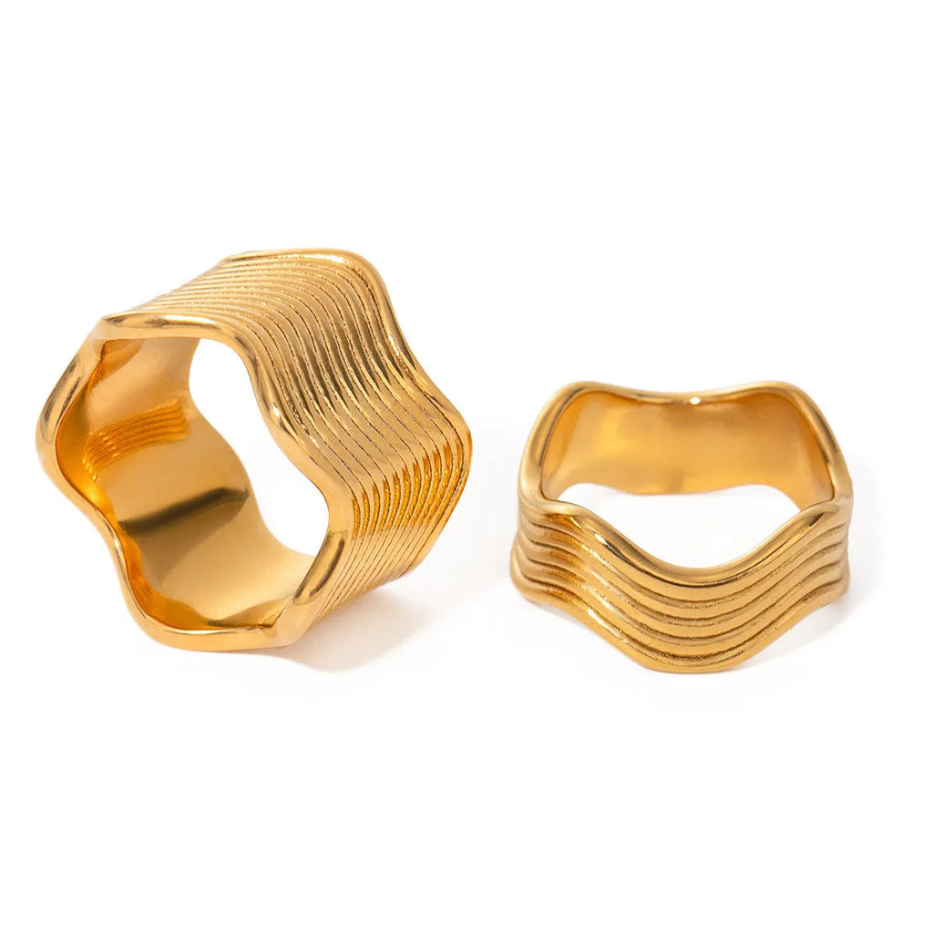 Stainless steel geometric wave ring with wide band design in silver and gold colour options.