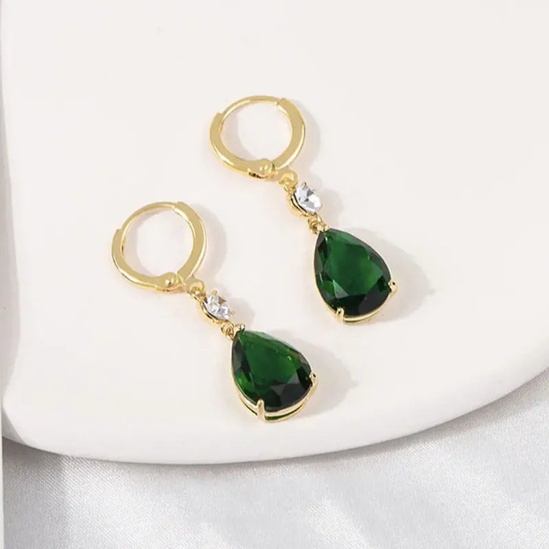 A pair of geometric green teardrop-shaped alloy drop earrings on a white background.