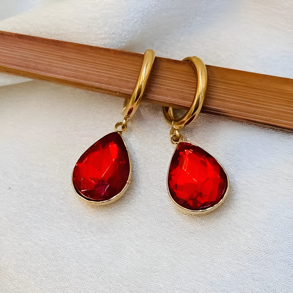 Geometric copper-coloured glass water drop earrings with a Saturn design element.