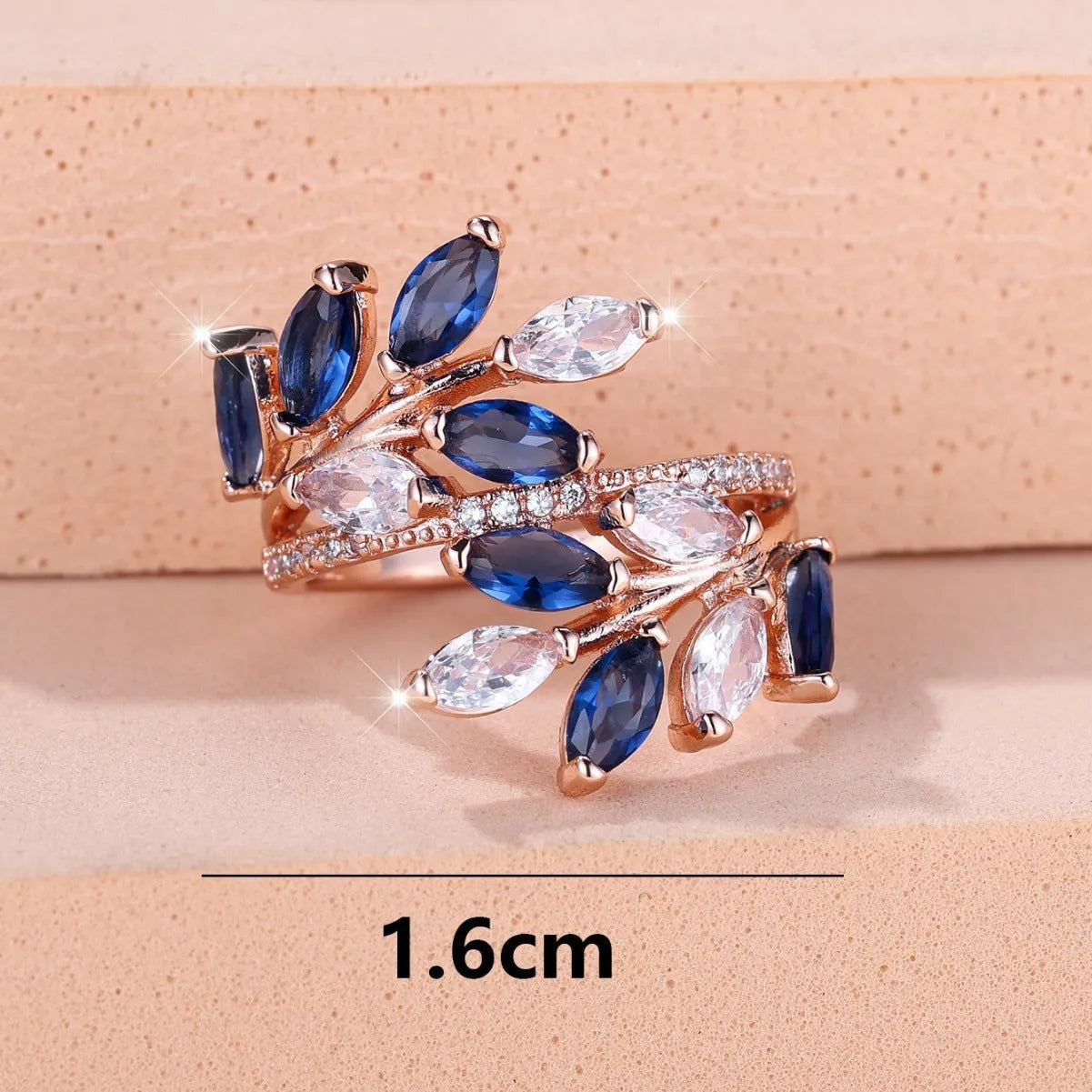 Adjustable copper leaf-shaped ring with zircon stones in various colour options on a white background.