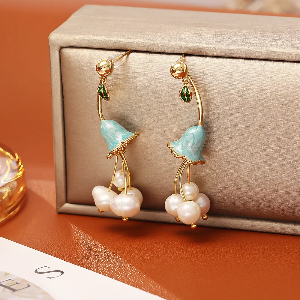 Natural baroque pearl ear studs with 14K real gold plated lily flower copper setting on white background