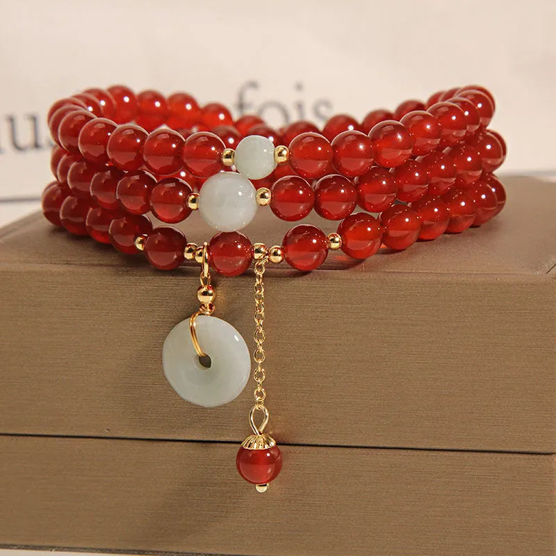 Women's multi-layer bracelet with red agate stones and crystal embellishments on adjustable band