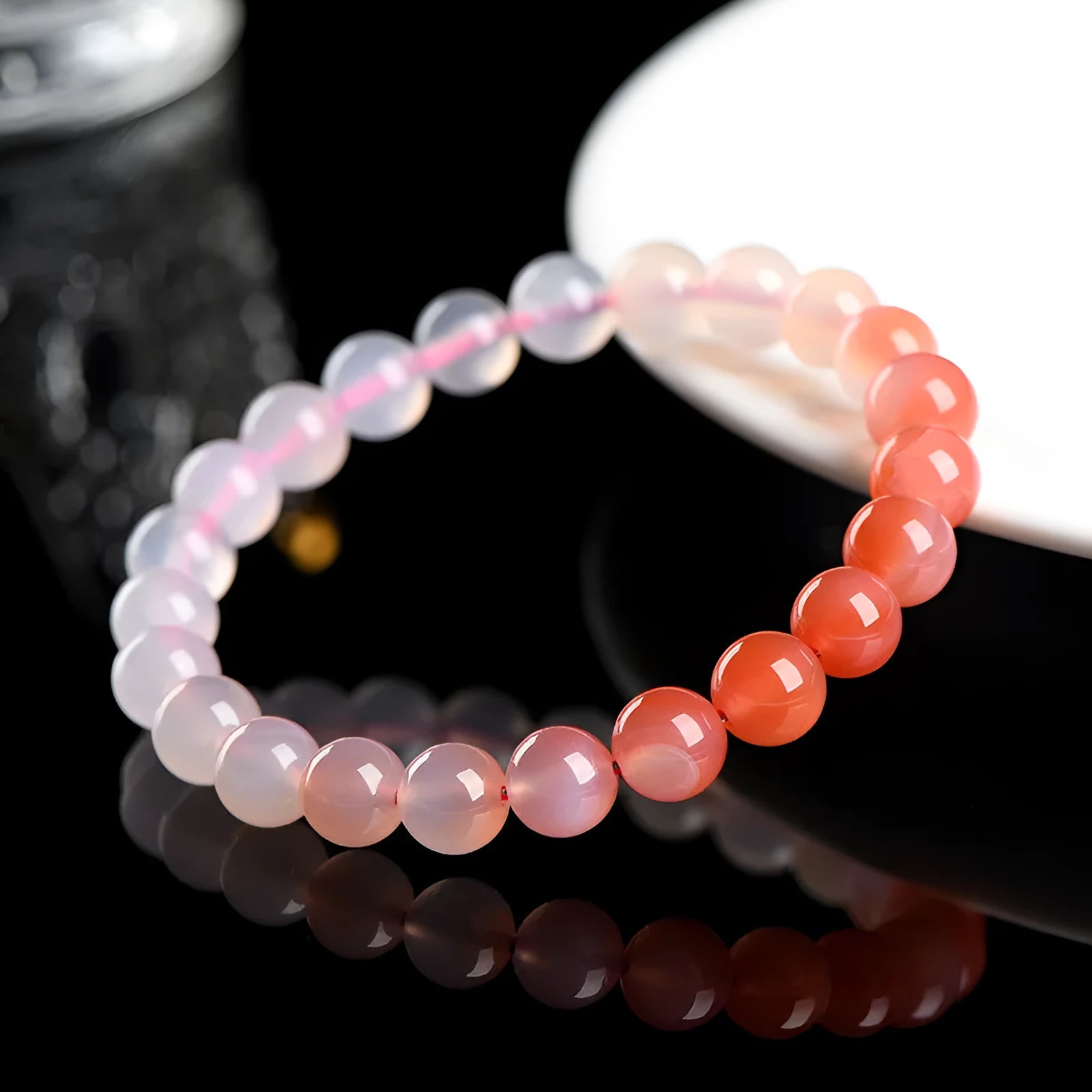 A gradient coloured Yanyuan agate bracelet with polished geometry-shaped beads on a white background.