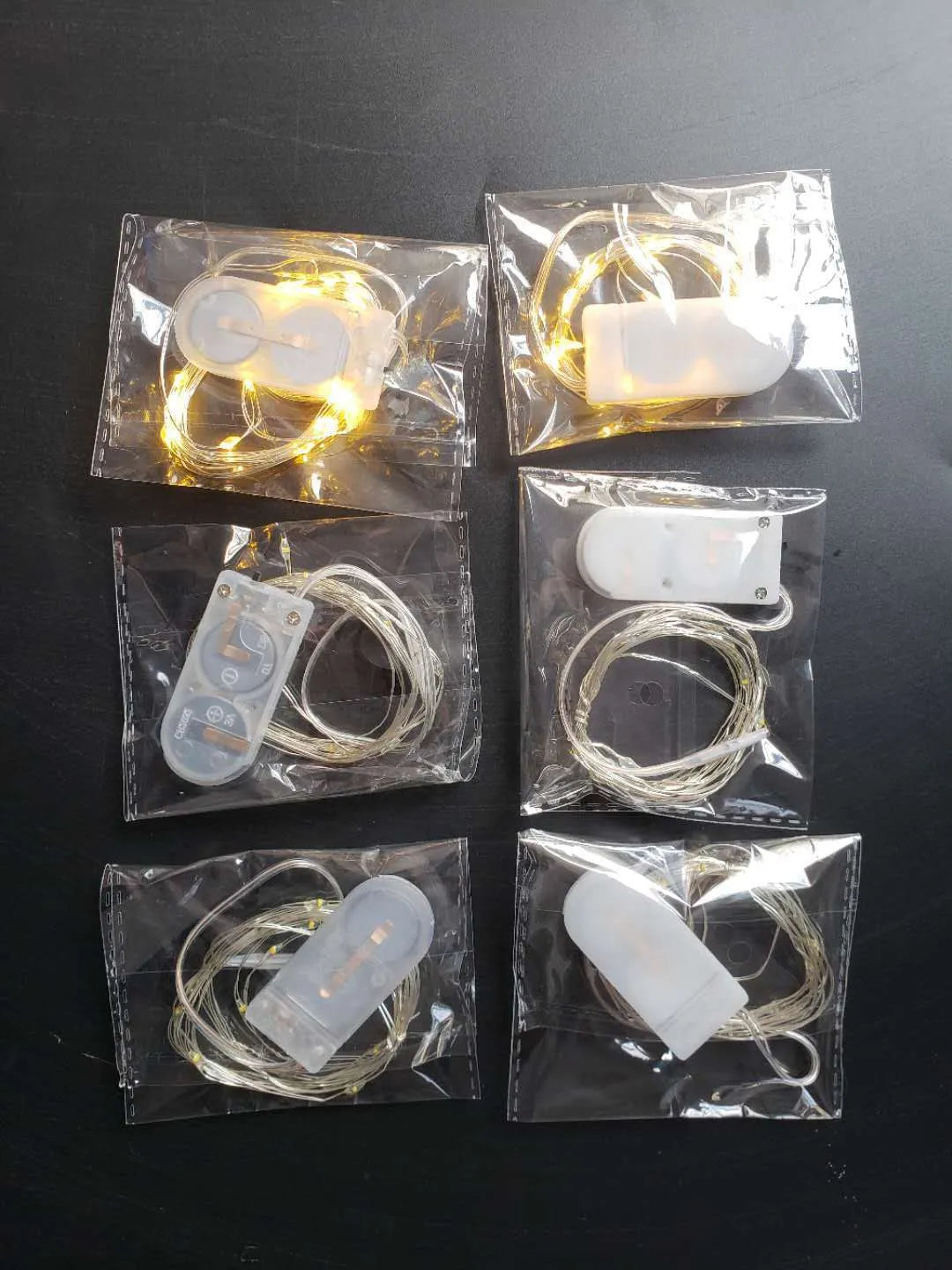 Copper wire LED fairy light string with 20 small button lights and a white plastic battery box.