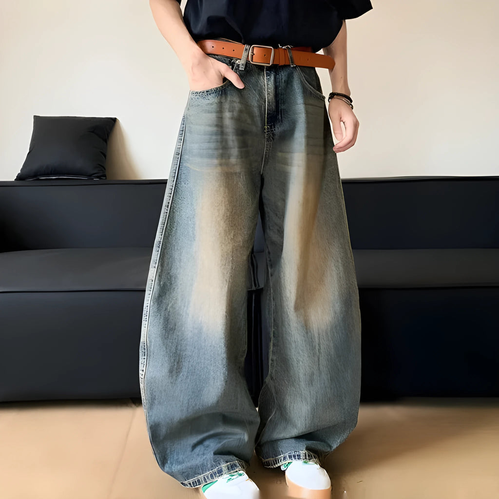 Retro blue men's distressed wide-leg jeans on a neutral background, showing machete detailing and mid-waist zip fly.