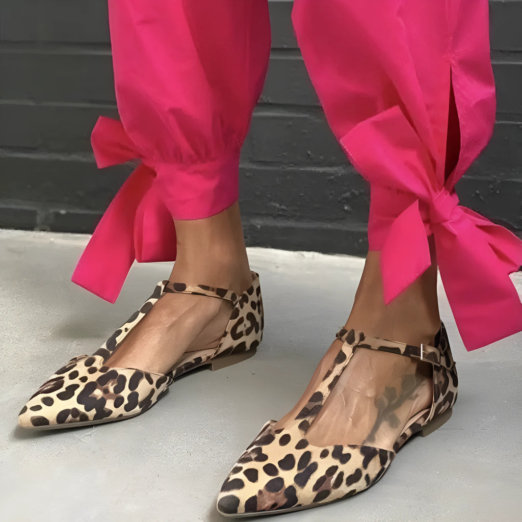 Leopard print women's court shoes with a pointed toe, cross strap, and a low chunky heel.