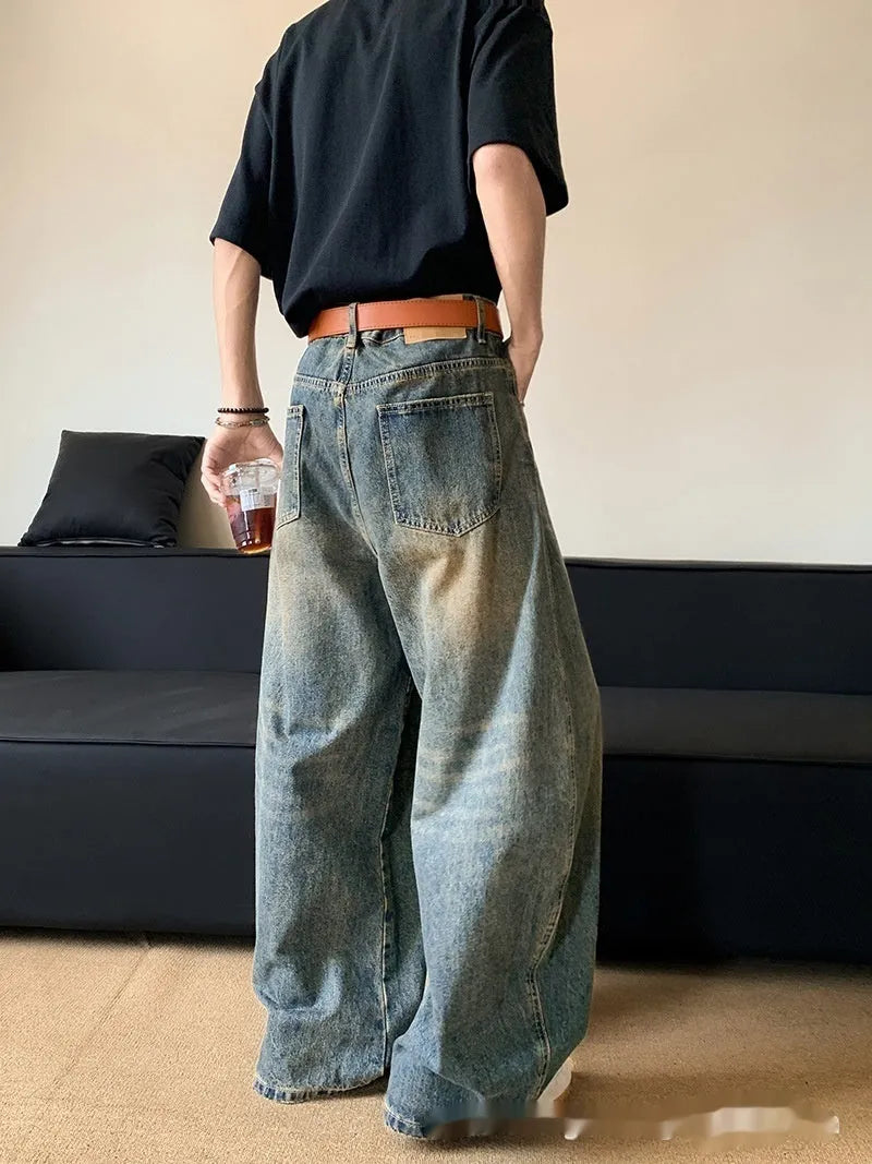 Retro blue men's distressed wide-leg jeans on a neutral background, showing machete detailing and mid-waist zip fly.