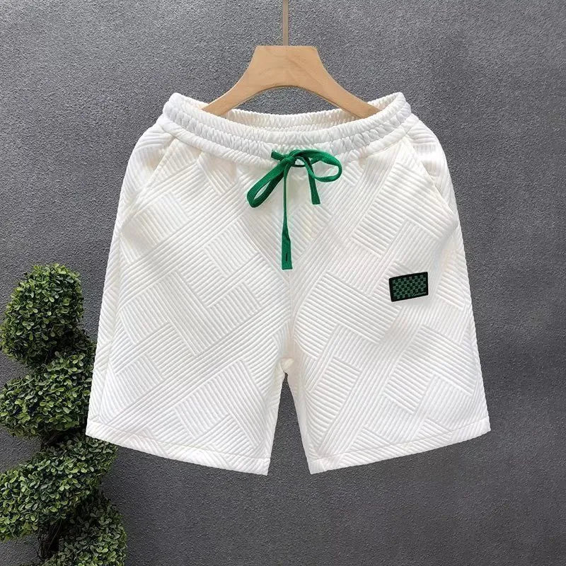 Men's solid colour polyester sports shorts on a hanger, showing elastic waistband.