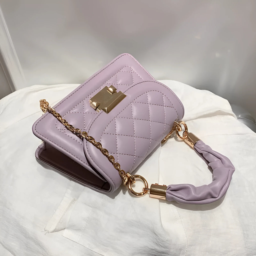 Purple rhombus-shaped women's shoulder bag with a chain strap on a white background.