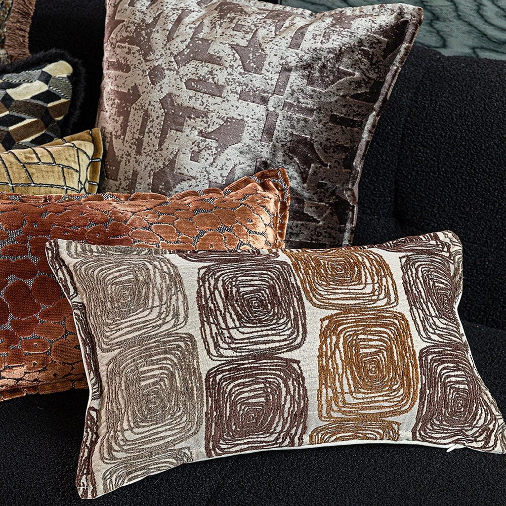 Cream and coffee-coloured abstract coil pattern square pillow cover 50x50cm on a grey sofa.